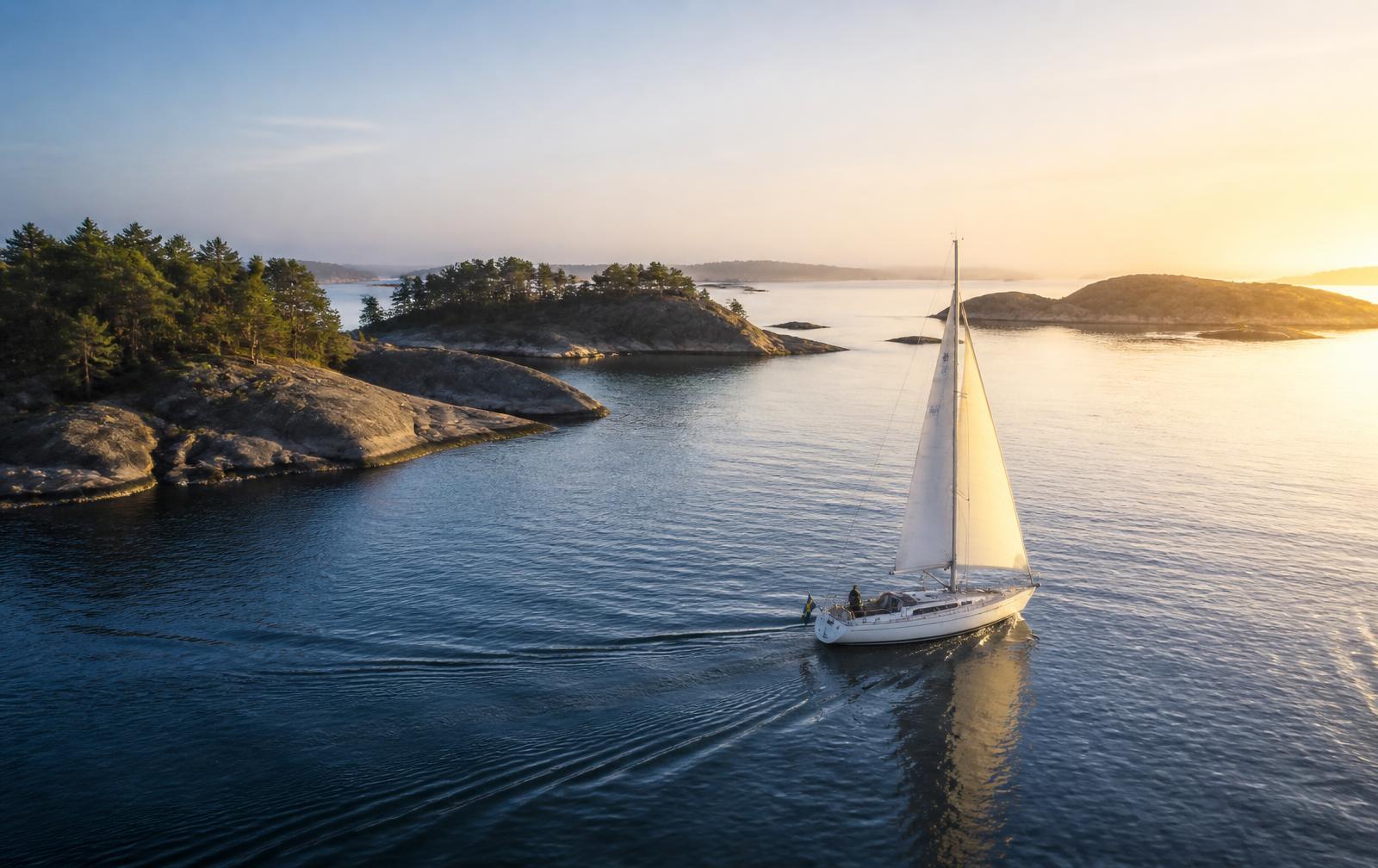 Seilbåt i norsk skjærgård i solnedgang